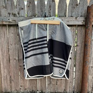 Linerless hybrid board shorts w/ 8” inseam, scalloped hem, two zippered pockets